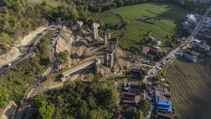 Foto udara sejumlah kendaraan melintas di dekat proyek pembangunan jalan layang atau Elevated Road di Tompo Ladang Desa Padaelo Kabupaten Maros, Sulawesi Selatan, Selasa (29/10/2024). Pembangunan jalan layang yang menghubungkan Kabupaten Maros dan Kabupaten Bone, sepanjang 200 meter tersebut dengan anggaran sebesar Rp125 Miliar itu ditargetkan rampung pada akhir Desember 2024 guna mendukung kelancaran distribusi barang ke beberapa daerah di Sulsel. ANTARA FOTO/Andri Saputra/aww.