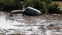 Sejumlah mobil juga terlihat mengambang di antara sampah yang terbawa aliran banjir.