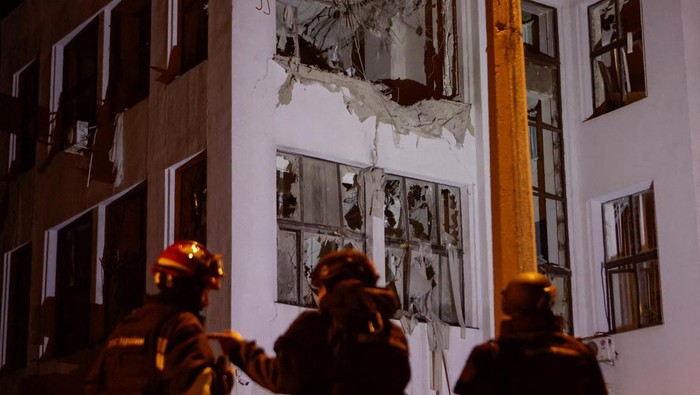 Rescuers stand in front of the State Industry House (Derzhprom) hit by a Russian air strike, amid Russia's attack on Ukraine, in Kharkiv, Ukraine October 28, 2024. REUTERS/Sofiia Gatilova     TPX IMAGES OF THE DAY
