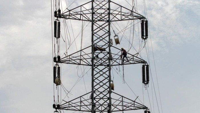 Pekerja memasang kawat penghantar pada menara Saluran Udara Tegangan Ekstra Tinggi (SUTET) di Buduran, Sidoarjo, Jawa Timur, Sabtu (19/10/2024). Pemerintah melalui Kementerian Energi dan Sumber Daya Mineral (ESDM) memutuskan tarif tenaga listrik Triw