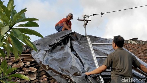 Warga memperbaiki atap rumah yang diterjang angin puting beliung di Sempidi, Kecamatan Mengwi, Badung, Rabu (30/10/2024).
