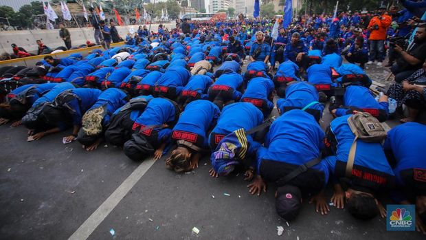 Buruh melakukan sujud syukur saat aksi unjuk rasa di kawasan Patung Kuda, Jalan Medan Merdeka Barat, Jakarta, Kamis (31/10/2024). (CNBC Indonesia/Faisal Rahman)