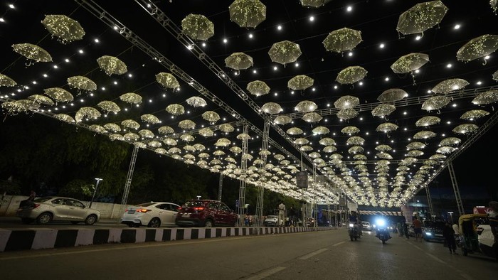 Girls takes selfie on an illuminated road on the Hindu festival of lights Diwali in Ahmedabad, India, Thursday, Oct. 31, 2024. (AP Photo/Ajit Solanki)