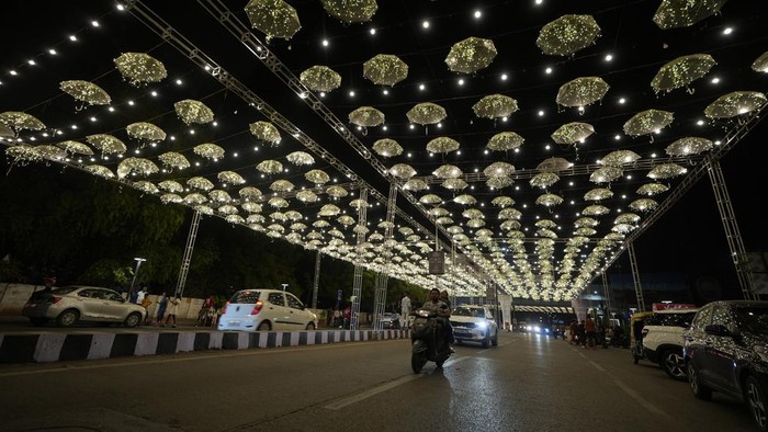 Girls takes selfie on an illuminated road on the Hindu festival of lights Diwali in Ahmedabad, India, Thursday, Oct. 31, 2024. (AP Photo/Ajit Solanki)