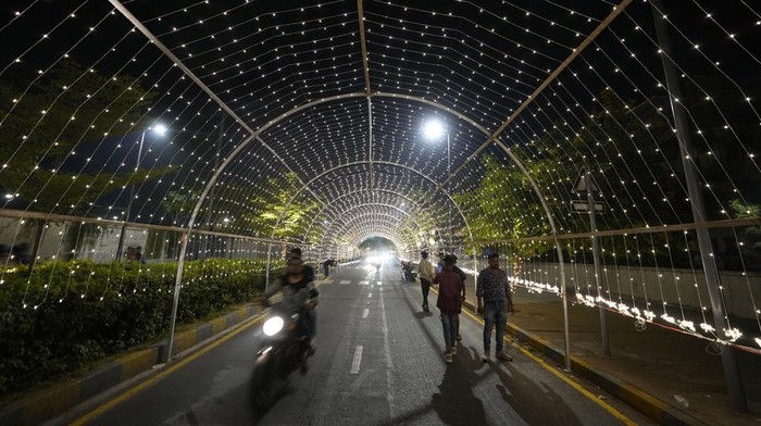 Girls takes selfie on an illuminated road on the Hindu festival of lights Diwali in Ahmedabad, India, Thursday, Oct. 31, 2024. (AP Photo/Ajit Solanki)