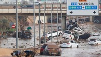 Mobil-mobil yang rusak terlihat di sepanjang jalan yang terkena hujan deras yang menyebabkan banjir, di pinggiran Valencia, Spanyol, Kamis (31/10/2024).