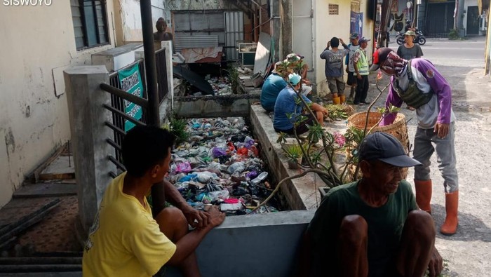 Petugas dan warga saat membersihkan sampah yang menumpuk di saluran air Jalan Kusumanegara No. 7D, RT 32 Plumbon, Banguntapan, Bantul, Kamis (31/10/2024).