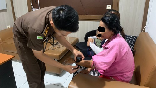 Petugas memasang gelang GPS ke tangan tahanan kota Kejari Jembrana beberapa waktu lalu.