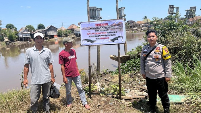 Polsek Jejawi OKI menyebarkan spanduk waspada terhadap buaya di Sungai Jejawi OKI.