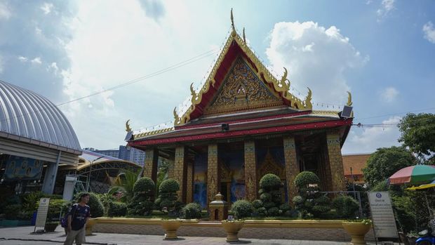 People walk past the Wat Mahabut Temple in Bangkok, Friday, Oct. 25, 2024. (AP Photo/Sakchai Lalit)