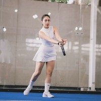 Selebgram Ayla Dimitri tampil serba putih dengan padanan crop top, rok mini, kaus kaki dan sneakers putih. Olahraga raket ini sering dianggap lebih sosial daripada tennis karena format timnya dan suasana permainan yang lebih santai. Foto: Instagram