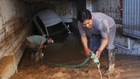 Badai ini mengakibatkan banjir besar dan arus air berlumpur yang merusak rumah-rumah serta menyapu manusia dan kendaraan. Pemerintah meminta warga di wilayah terdampak untuk tetap berada di dalam rumah sementara petugas penyelamat terus mencari korban yang masih selamat. (AP Photo/Alberto Saiz) 