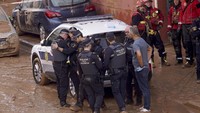 Anggota kepolisian mengevakuasi salah satu rekan mereka yang meninggal akibat banjir di Valencia, Spanyol, Kamis (31/10/2024). (AP Photo/Alberto Saiz) 