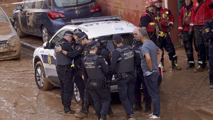 Banjir Dahsyat di Spanyol Tewaskan 158 Orang Members of the local police react to the news of one of their colleagues who died in the floods in Valencia, Spain, Thursday, Oct. 31, 2024. (AP Photo/Alberto Saiz)