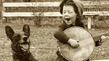 Seorang anak laki-laki memainkan banjo untuk anjingnya pada 1920. Foto: historyblackandwhite via Bored Panda