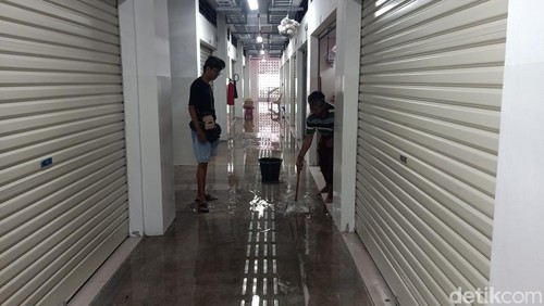 Sejumlah pedagang Pasar Umum Negara saat melakukan pembersihan air yang menggenang kios mereka, Jumat (1/11/2024). (I Putu Adi Budiastrawan/detikBali).