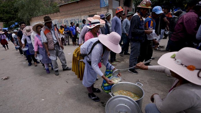 Pendukung eks Presiden Bolivia Morales bagi-bagi makanan saat melakukan aksi blokir jalan untuk hentikan proses penyelidikan Morales. ini fotonya.