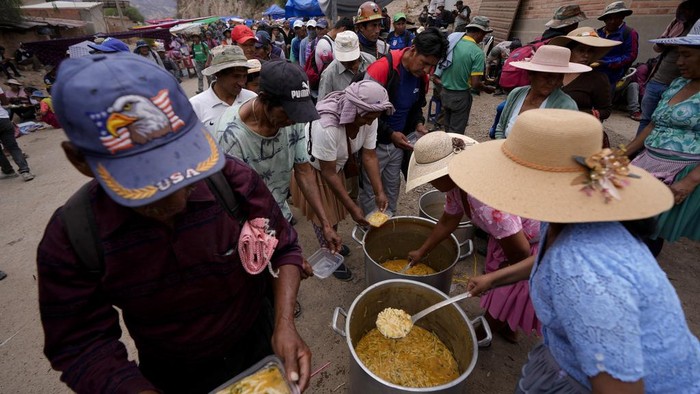 Pendukung eks Presiden Bolivia Morales bagi-bagi makanan saat melakukan aksi blokir jalan untuk hentikan proses penyelidikan Morales. ini fotonya.
