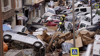 Puing-puing berserakan di sepanjang jalan dan mobil-mobil yang tersapu banjir tampak ringsek serta menutupi jalan. AP Photo/Alberto Saiz