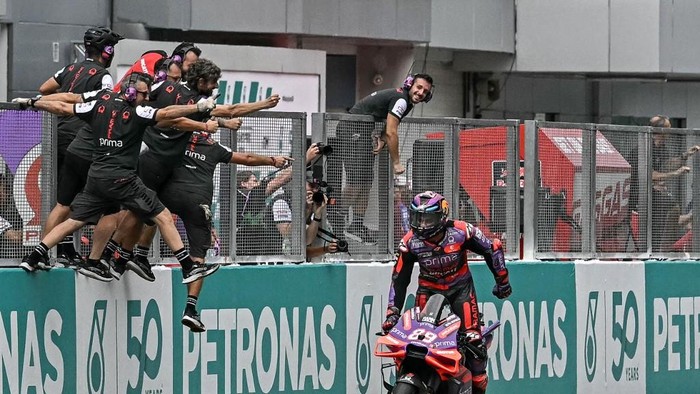 Prima Pramac Racings Spanish rider Jorge Martin celebrates as team members lean out to congratulate him for winning the Sprint race of the MotoGP Malaysian Grand Prix at the Sepang International Circuit in Sepang on November 2, 2024. (Photo by Lillian SUWANRUMPHA / AFP)