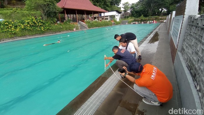 Polisi sedang mengukur kedalaman kolam yang menjadi lokasi pelajar meninggal dunia.