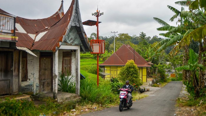 Sistem peringatan dini banjir lahar dingin Marapi Pengendara melintas di depan alat sistem peringatan dini atau Early Warning System bencana banjir lahar dingin Gunung Marapi di Nagari Sungai Jambu, Tanah Datar, Sumatera Barat, Sabtu (2/11/2024). Pemerintah memasang 23 alat sistem peringatan dini berupa perangkat sensor, kamera pengawas dan menara sirine di daerah yang masuk dalam kategori rawan potensi banjir lahar dingin yang lokasinya beririsan langsung dengan aliran sungai yang berhulu dari Gunung Marapi. ANTARA FOTO/Iggoy el Fitra/agr