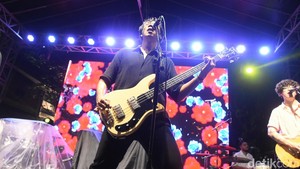 Suara vokalis yang kuat dan permainan gitar serta drum yang intens membuat suasana konser semakin hidup.