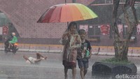 Sejumlah anak-anak menawarkan jasa ojek payung untuk warga di tengah hujan.
