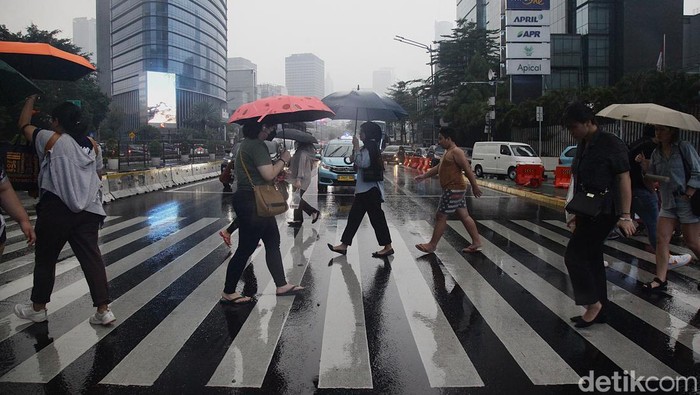 Hujan Deras Guyur Jakarta Warga menerobos hujan di kawasan Bundaran HI, Jakarta Minggu (3/11/2024).