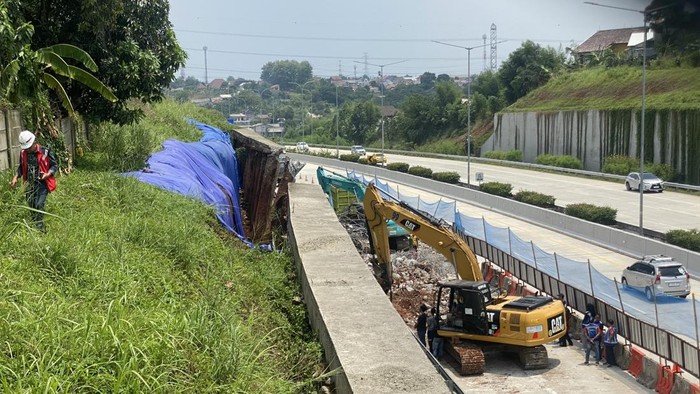 Tanggul jalan Tol Cinere-Serpong di Km 35.200-A jebol akibat hujan deras. Tanggul yang jebol itu kini sedang lama perbaikan oleh petugas, Minggu (3/11/2024).