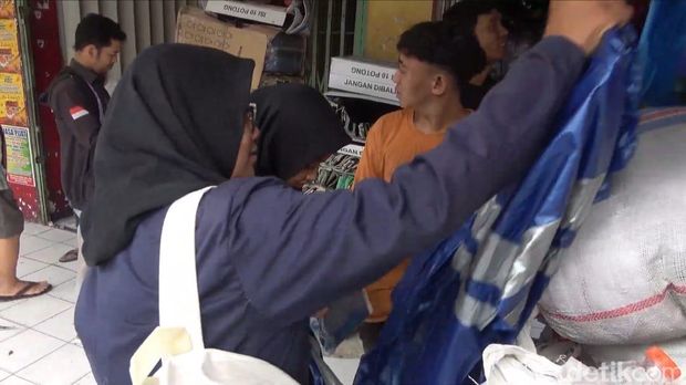 Warga Mencari Jas Hujan di Pasar Baru Lamongan