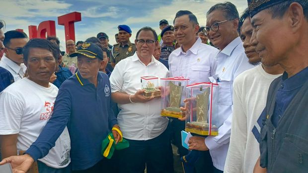 AHY dan Menteri PU Hanggodo diberikan kerajinan kulit kerang oleh warga Kalibaru. (CNBC Indonesia/Rosseno Aji)