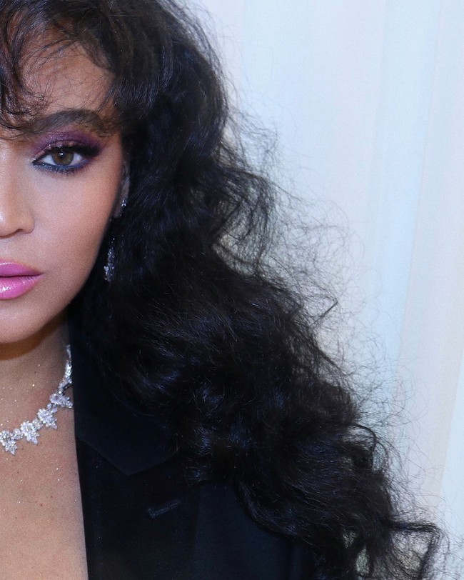 Di sebelah kanan, ia menampilkan interpretasi Apollonia dari era yang sama, dengan bodysuit hitam berenda dipadukan dengan sepatu bot ungu cerah dan jaket tailcoat. Foto: Instagram/@beyonce