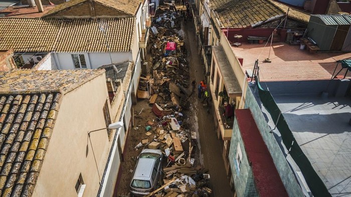 Volunteers and residents cleanup four days after flash floods swept away everything in their path in the town of Paiporta, the epicentre of the storm, outskirts of Valencia, Spain, Saturday, Nov. 2, 2024.(AP Photo/Angel Garcia)