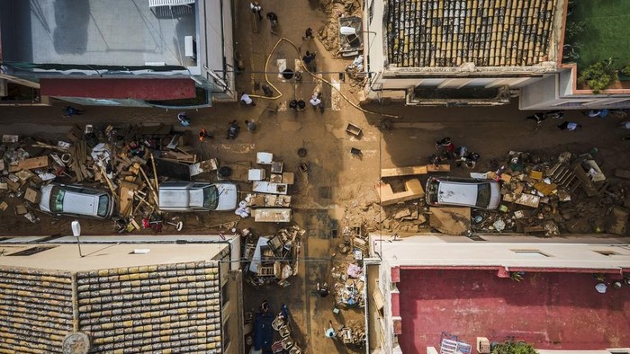 Volunteers and residents cleanup four days after flash floods swept away everything in their path in the town of Paiporta, the epicentre of the storm, outskirts of Valencia, Spain, Saturday, Nov. 2, 2024.(AP Photo/Angel Garcia)