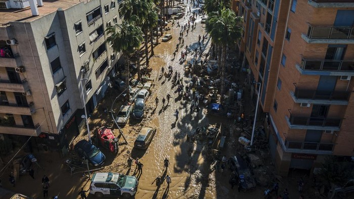 Volunteers and residents clean the mud four days after flash floods swept away everything in their path in Paiporta, outskirts of Valencia, Spain, Saturday, Nov. 2, 2024.(AP Photo/Angel Garcia)