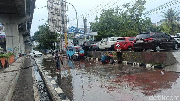 Jalan AP Pettarani Makassae depan BKKBN Sulsel tergenang usai diguyur hujan deras. Sejumlah motor mogok.