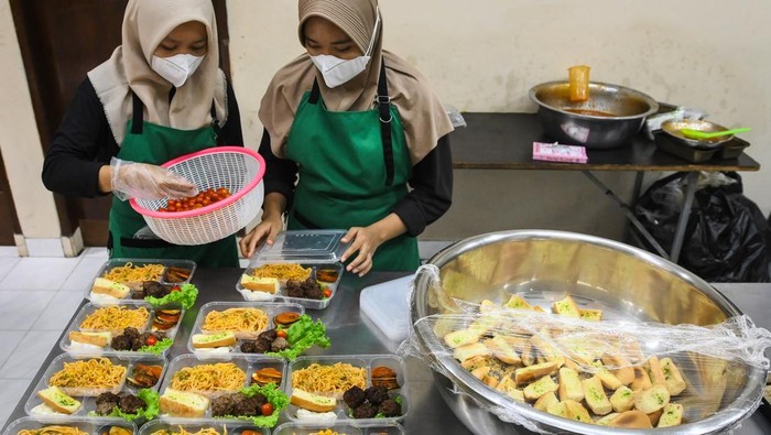Dua pekerja mengemas menu makanan diet sehat di Hanan Catering, Tangerang Selatan, Banten, Senin (4/11/2024). Jasa boga tersebut menyediakan ratusan menu makanan diet sehat seharga Rp50 ribu per menu guna membantu program diet dan menjaga kesehatan masyarakat. ANTARA FOTO/Sulthony Hasanuddin/rwa.