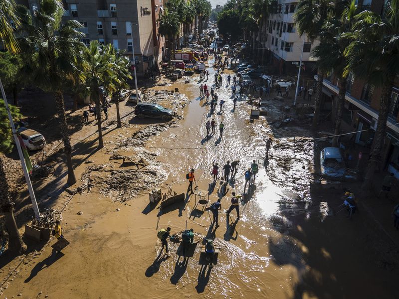 Volunteers return from helping affected municipalities four days after flash floods swept away everything in their path in the town of Paiporta, the epicentre of the storm, outskirts of Valencia, Spain, Saturday, Nov. 2, 2024.(AP Photo/Angel Garcia)