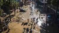 Sementara itu, ribuan sukarelawan berbondong-bondong membantu para korban bencana banjir dengan membawa makanan dan air, serta sekop untuk membersihkan lumpur yang menutupi jalan. (AP Photo/Angel Garcia)