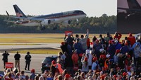 Trump Force One terbang melintas, saat para pendukung calon presiden dari Partai Republik dan mantan Presiden AS Donald Trump menghadiri rapat umum di Kinston, North Carolina, Amerika Serikat, Minggu (3/11/2024). (REUTERS/Jonathan Drake)  