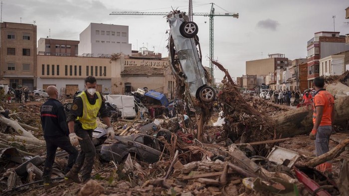Momen Raja-Ratu Spanyol Dilempari Lumpur Saat Tinjau Lokasi Banjir Emergency services remove cars in an area affected by floods in Catarroja, Spain, on Sunday, Nov. 3, 2024. (AP Photo/Manu Fernandez)