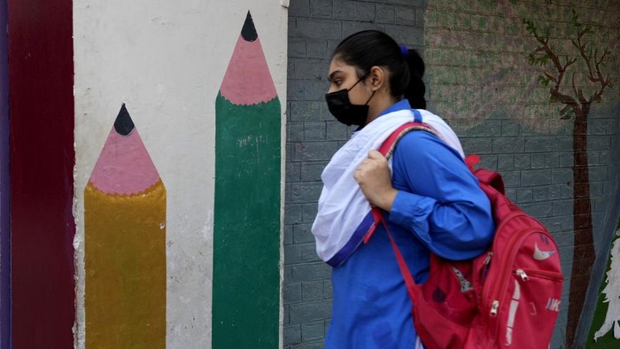 Pakistan Tutup Sekolah Dasar di Lahore Gegara Polusi Udara Makin Parah A teacher and students wear mask to protect themselves from poor air quality due to increasing smog in the city as they attend their school, in Lahore, Pakistan, Monday, Nov. 4, 2024. (AP Photo/K.M. Chaudary)