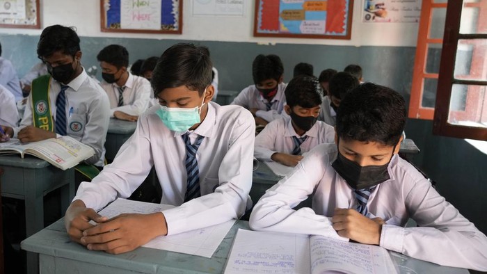 Pakistan Tutup Sekolah Dasar di Lahore Gegara Polusi Udara Makin Parah A teacher and students wear mask to protect themselves from poor air quality due to increasing smog in the city as they attend their school, in Lahore, Pakistan, Monday, Nov. 4, 2024. (AP Photo/K.M. Chaudary)