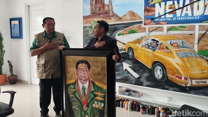 Pelukis muda Indonesia, Naufal Abshar memberikan hadiah berupa lukisan kepada Presiden RI ke-6 Susilo Bambang Yudhyono (SBY). (Maulana IF/detikcom)