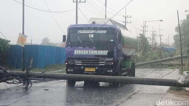 Tiang listrik roboh akibat hujan deras disertai angin kencang di Sidoarjo.
