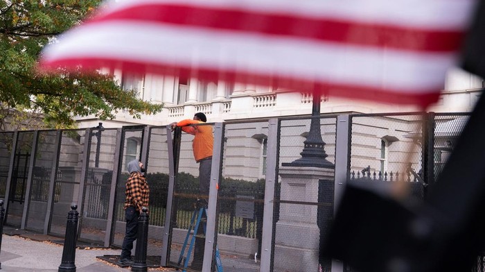 Gedung Putih Perketat Keamanan Jelang Pilpres AS A member of the U.S. Secret Service closes a security gate along Pennsylvania Avenue near the White House on the day before the U.S. presidential election in Washington, U.S., November 4, 2024. REUTERS/Nathan Howard