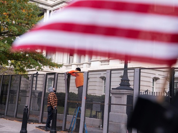 A member of the U.S. Secret Service closes a security gate along Pennsylvania Avenue near the White House on the day before the U.S. presidential election in Washington, U.S., November 4, 2024. REUTERS/Nathan Howard