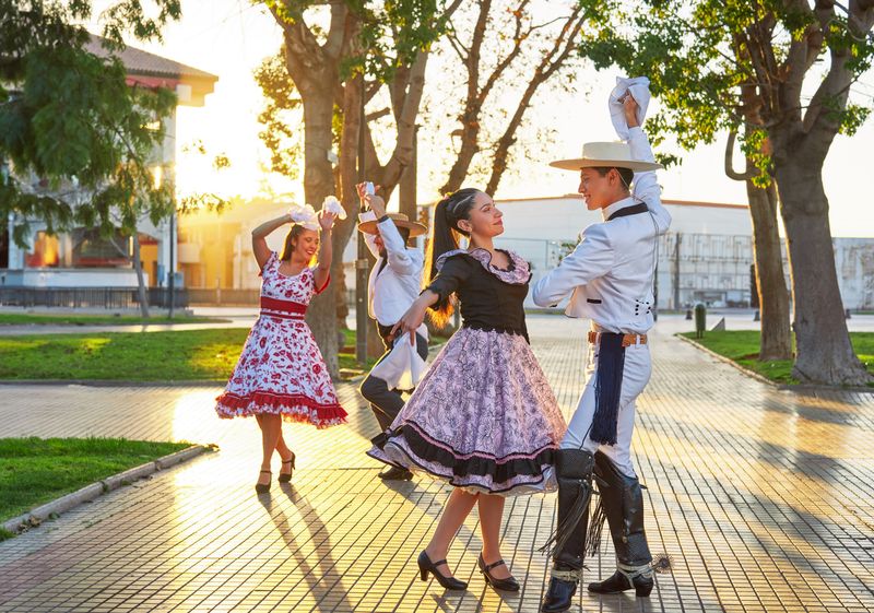 International Mariachi and Charrería Festival di Meksiko group of two Latin American couples of huaso dancing cueca in the town square at sunset in La Serena