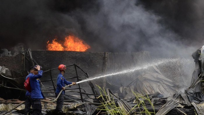 Petugas pemadam kebakaran berusaha memadamkan api yang membakar gudang penampungan BBM jenis solar di Teluk Betung Timur, Bandar Lampung, Lampung, Senin (4/11/2024). Dinas Pemadam Kebakaran Kota Bandar Lampung mengerahkan puluhan unit mobil pemadam kebakaran dan satu unit mobil water cannon milik Polda Lampung ke lokasi kebakaran untuk melakukan pemadaman, sementara penyebab kebakaran masih belum diketahui. ANTARA FOTO/Ardiansyah/tom.